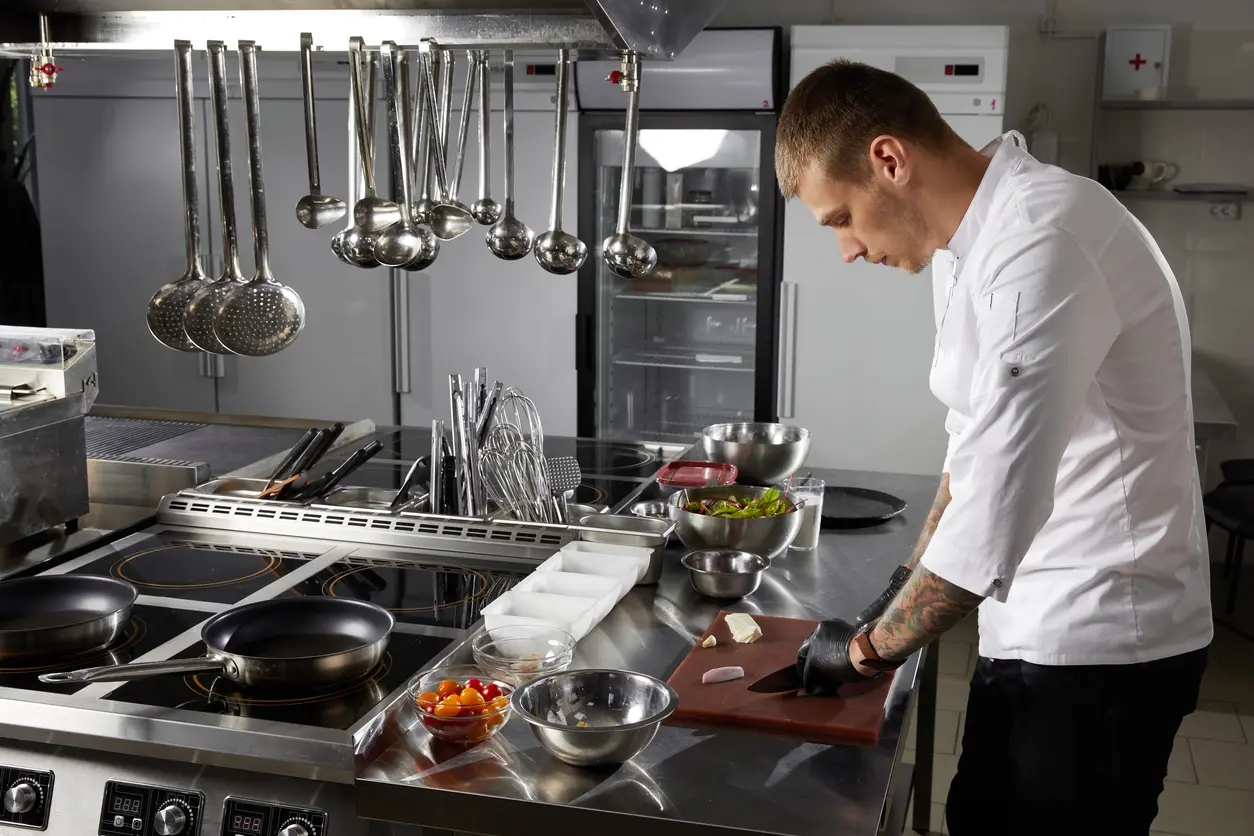 Cocinero en su mesón de acero inoxidable
